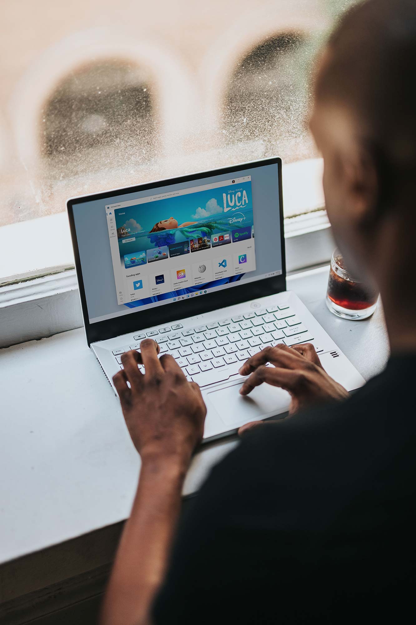 A friendly nutrition writer working at a laptop with food illustrations nearby